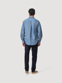 Reverse shot of model wearing a blue denim chambray shirt and dark blue corduroy trousers on a white background